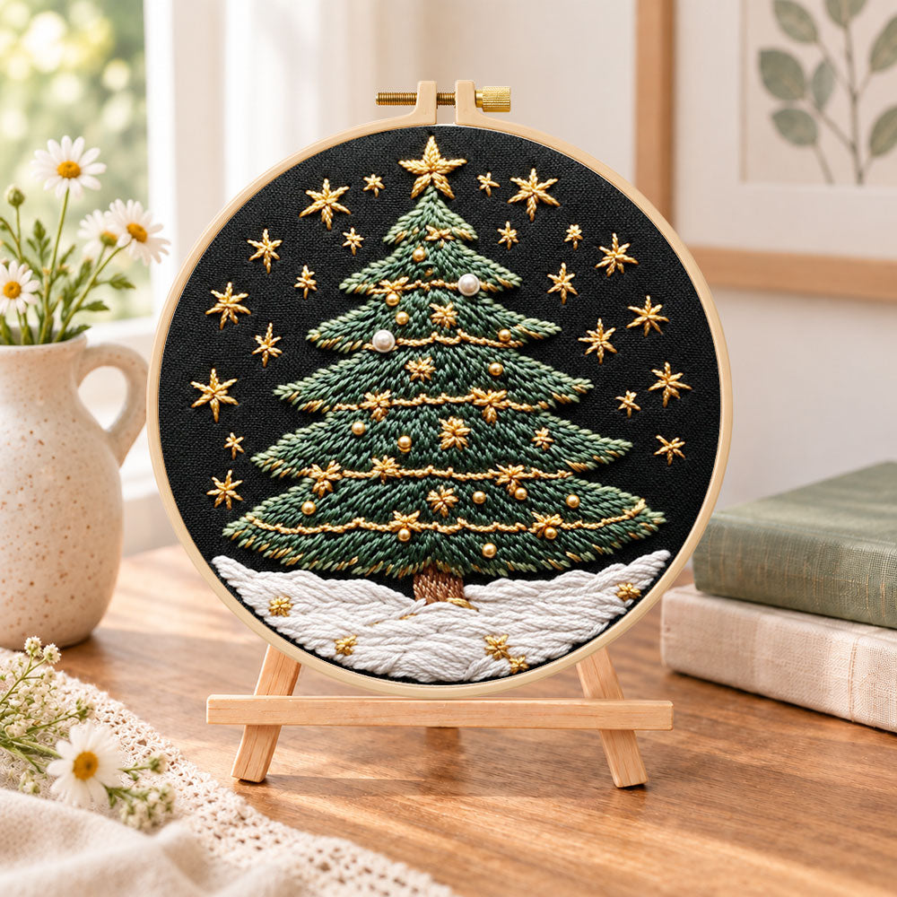 Snowy star christmas tree embroidery kit finished hoop displayed on a wooden stand as cosy tabletop decor