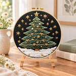 Snowy star christmas tree embroidery kit finished hoop displayed on a wooden stand as cosy tabletop decor