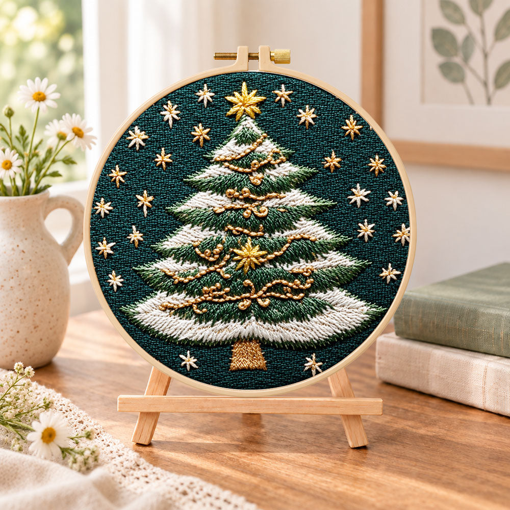 Snowy striped christmas tree embroidery kit finished hoop displayed on a wooden stand as cosy tabletop decor