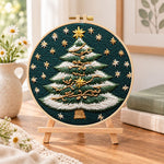 Snowy striped christmas tree embroidery kit finished hoop displayed on a wooden stand as cosy tabletop decor