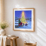 Snowy village with glowing christmas tree cross stitch artwork displayed on wall as home decor