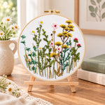 Soft wild daisy mix embroidery kit finished hoop displayed on a wooden stand as cosy tabletop decor