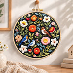 Songbirds and vibrant blooms embroidery hoop wall art displayed as warm and cosy handmade home decor