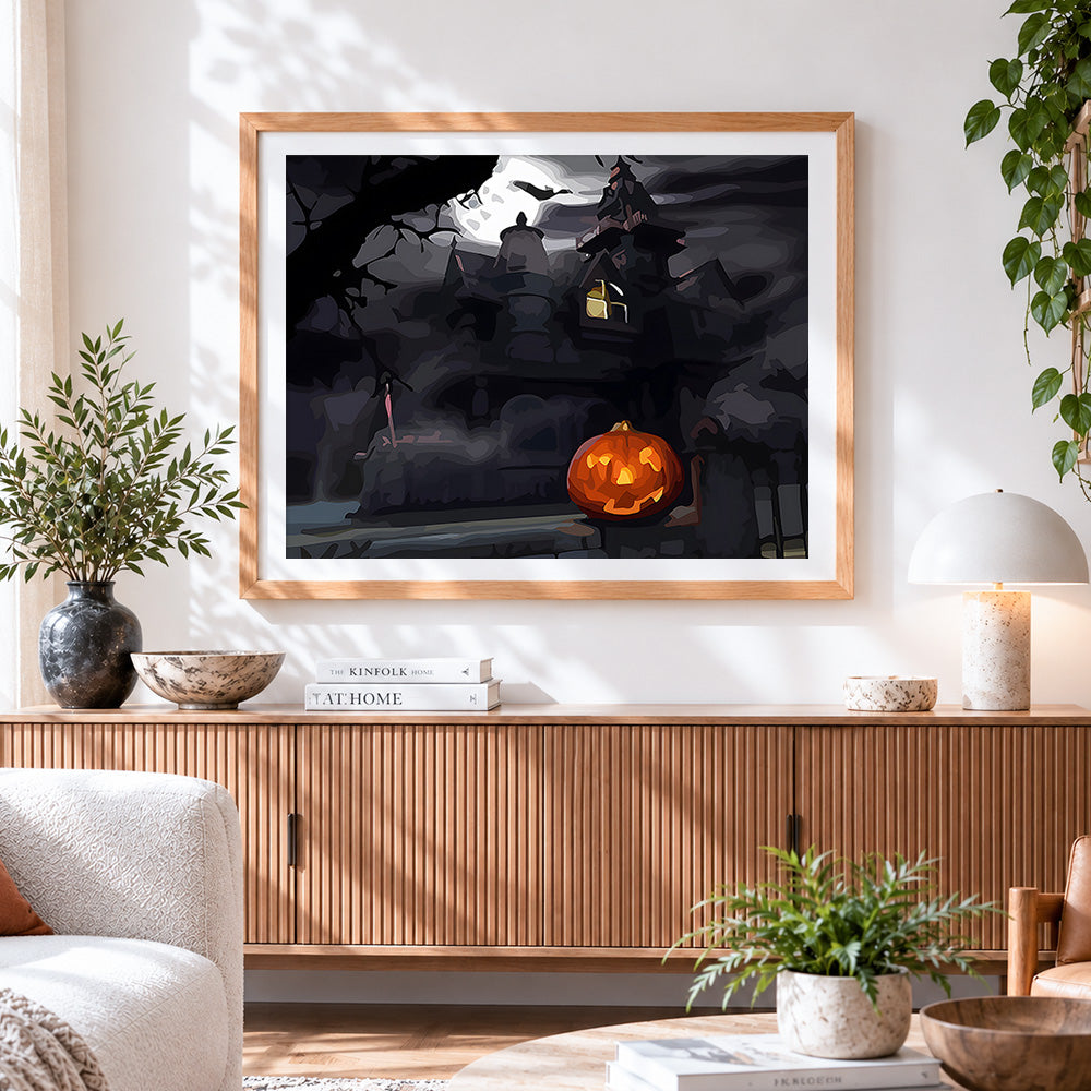 Finished spooky haunted house and glowing pumpkin cross stitch artwork displayed