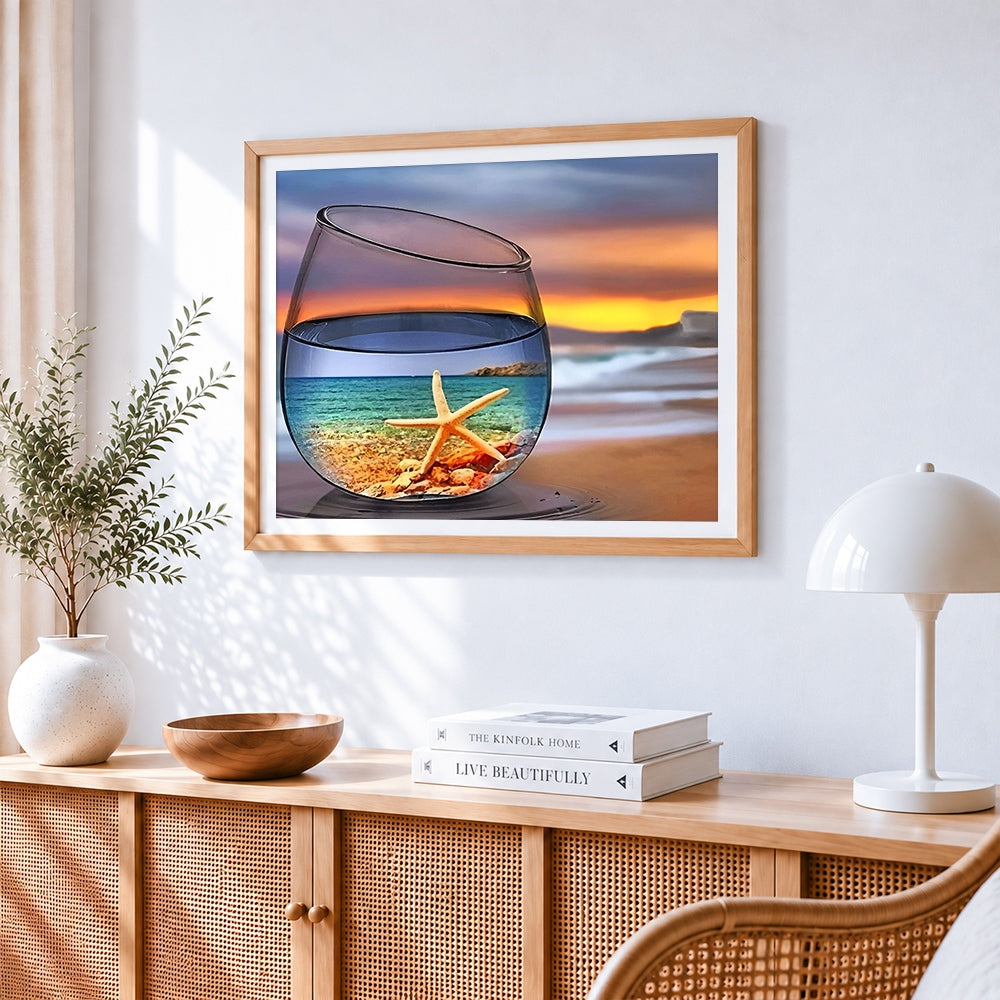 Starfish and beach in a wine glass cross stitch artwork displayed on wall as home decor