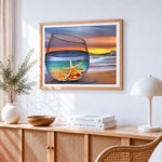 Starfish and beach in a wine glass cross stitch artwork displayed on wall as home decor
