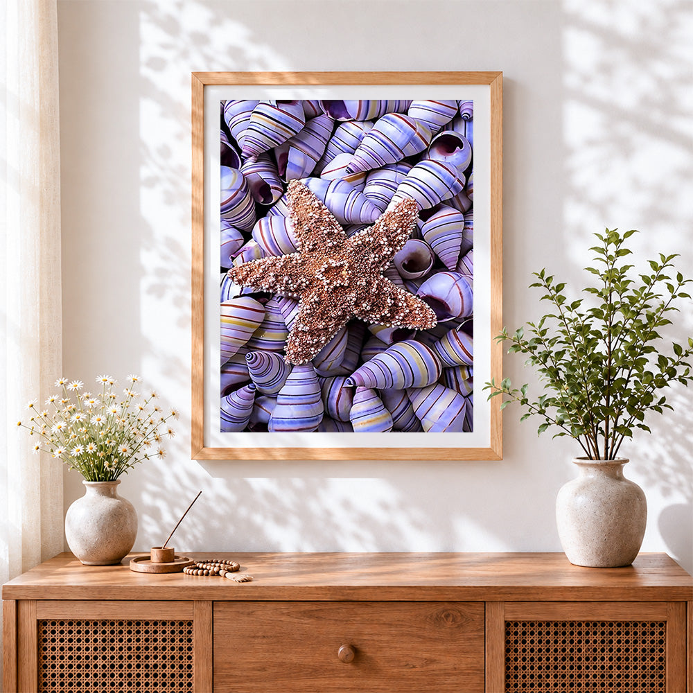 Finished starfish on purple striped shells cross stitch artwork displayed