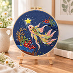 Starry koi fish embroidery kit finished hoop displayed on a wooden stand as cosy tabletop decor