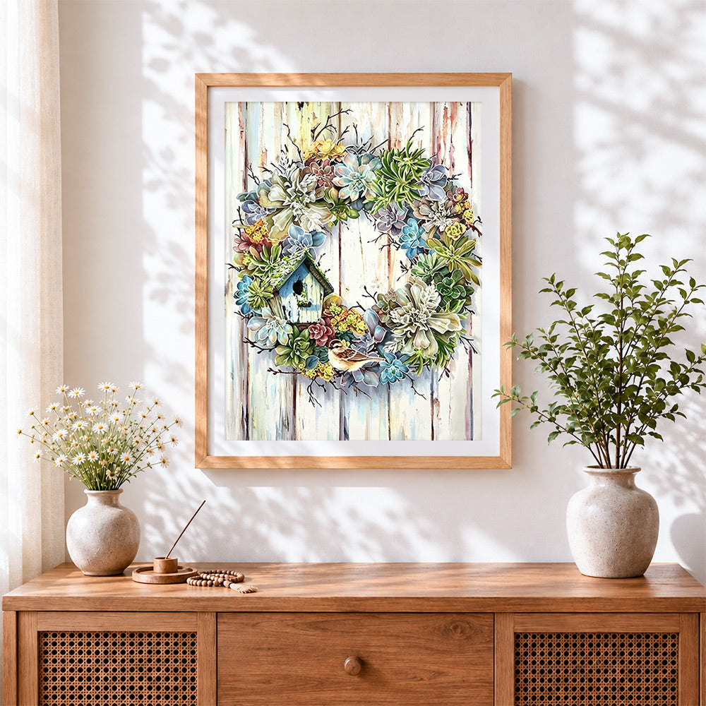 Finished succulent wreath with birdhouse cross stitch artwork displayed