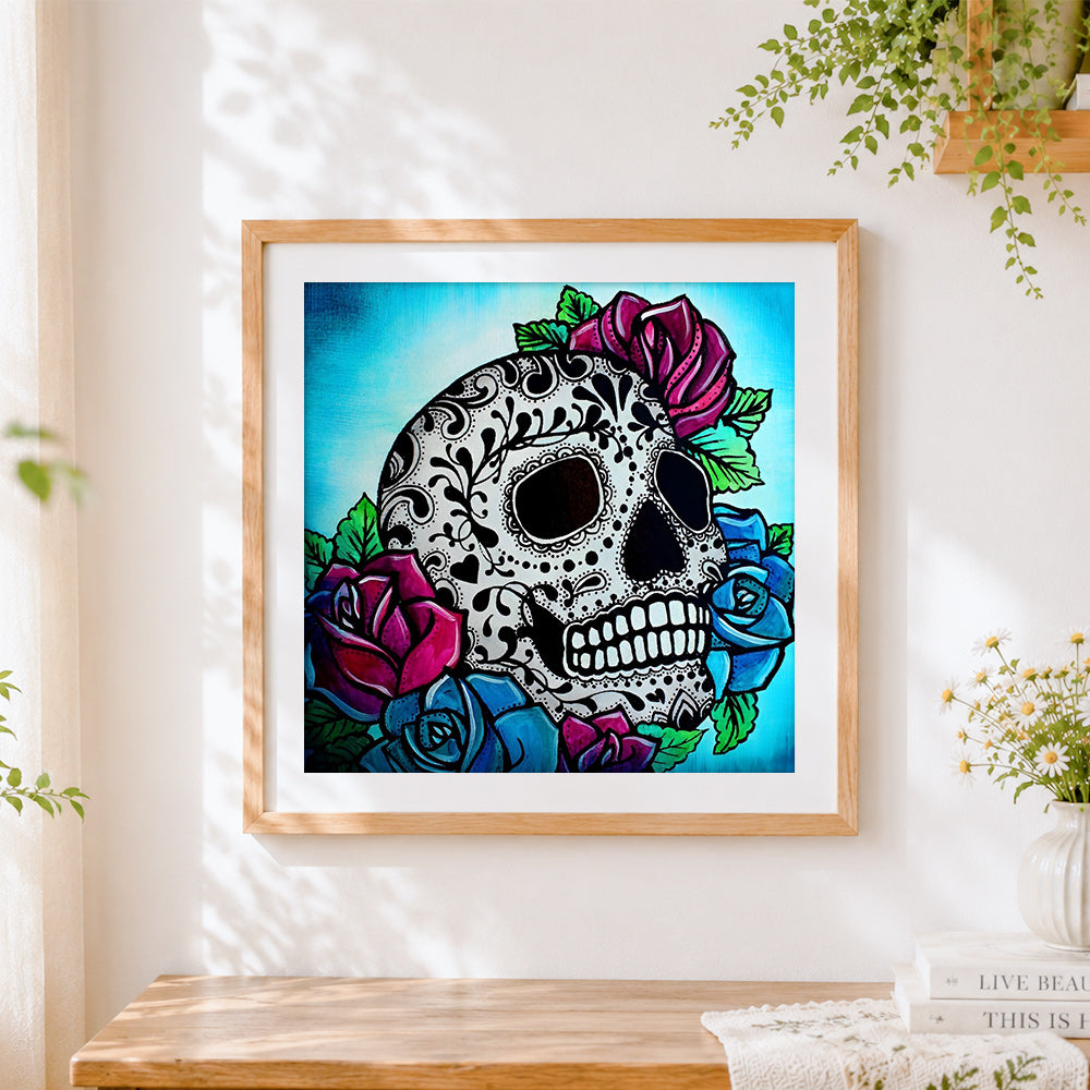 Finished sugar skull with red and blue roses cross stitch artwork displayed