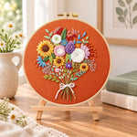 Sunflower bouquet on rust embroidery kit finished hoop displayed on a wooden stand as cosy tabletop decor