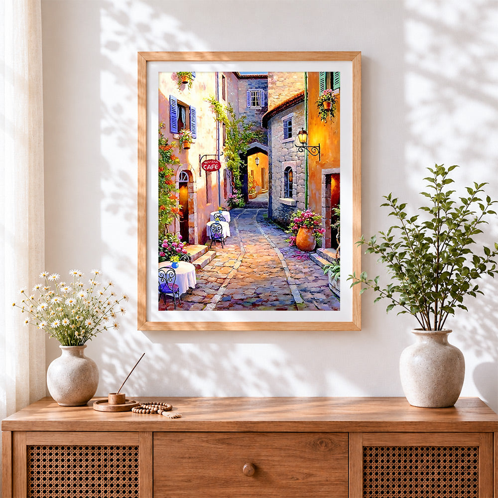 Finished sunlit european cafe street cross stitch artwork displayed