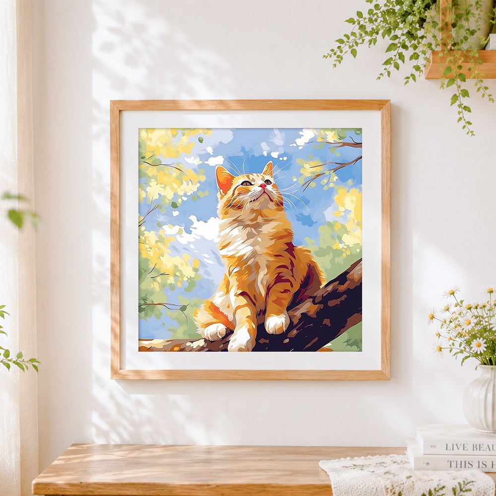 Finished sunlit ginger cat sitting in a tree cross stitch artwork displayed