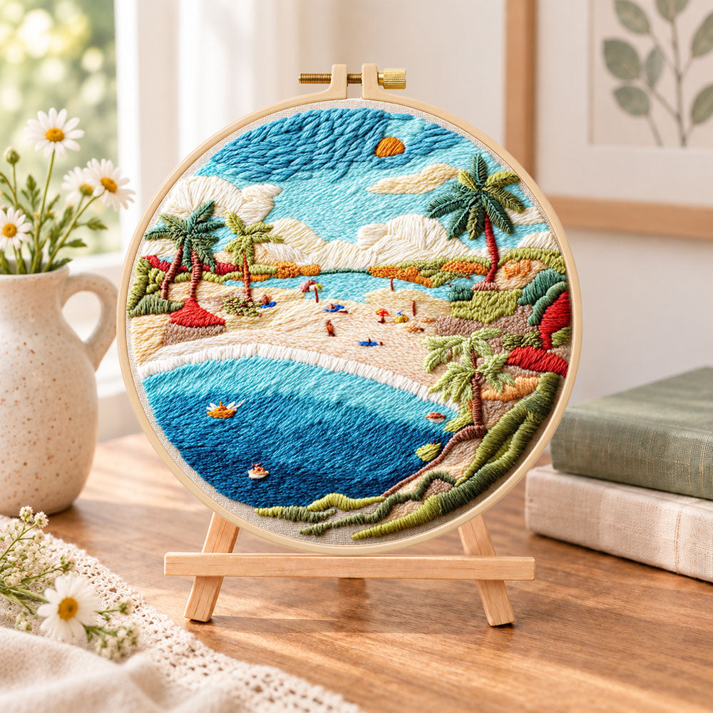 Sunny beach bay embroidery kit finished hoop displayed on a wooden stand as cosy tabletop decor