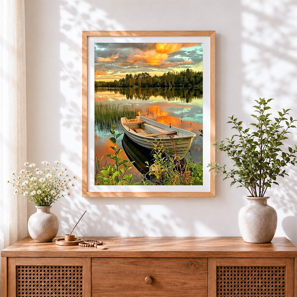 Finished sunset lake boat cross stitch artwork displayed