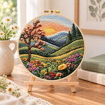 Sunset mountain bloom embroidery kit finished hoop displayed on a wooden stand as cozy tabletop decor