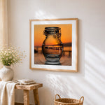 Sunset pier in glass jar cross stitch artwork displayed on wall as home decor