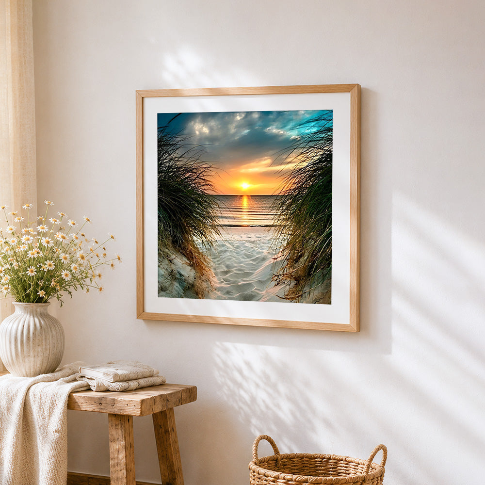 Sunset through beach dune grass cross stitch artwork displayed on wall as home decor
