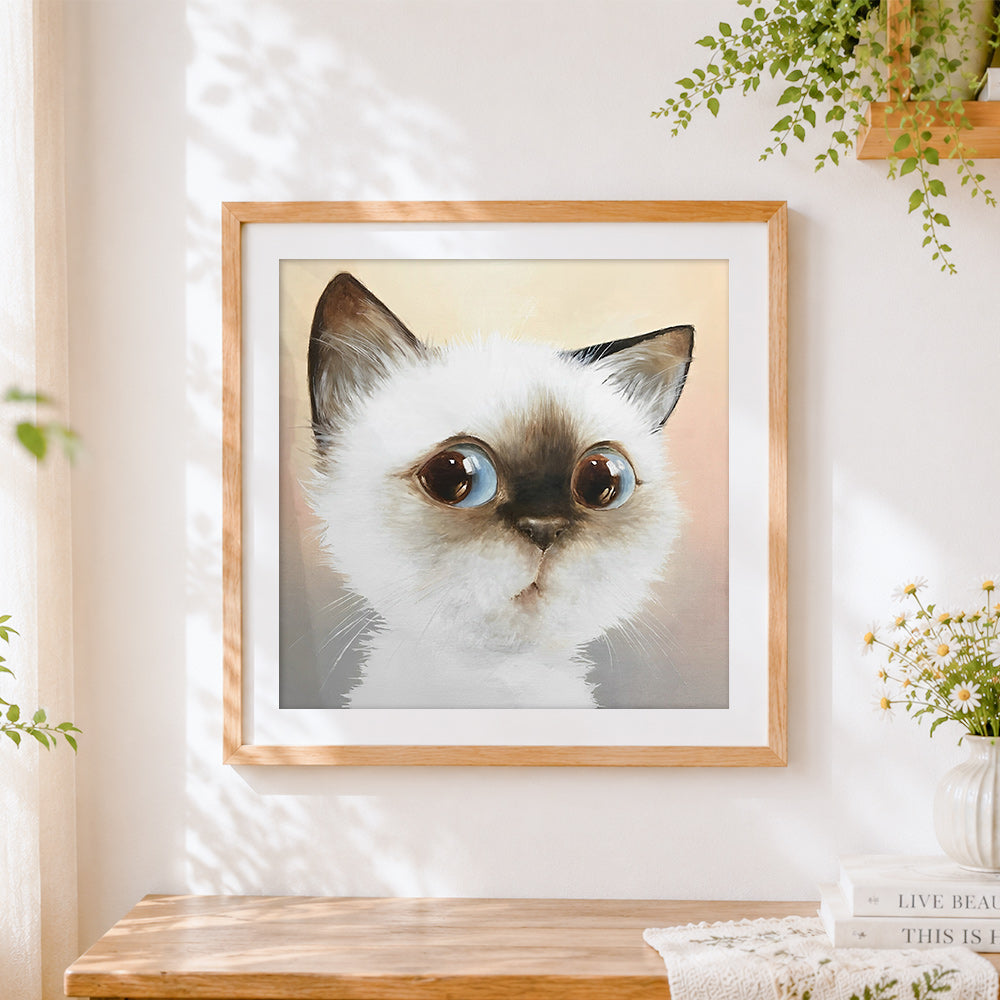 Finished surprised cat face cross stitch artwork displayed
