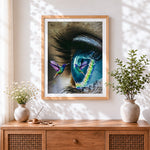 Finished surreal blue eye and a hummingbird cross stitch artwork displayed