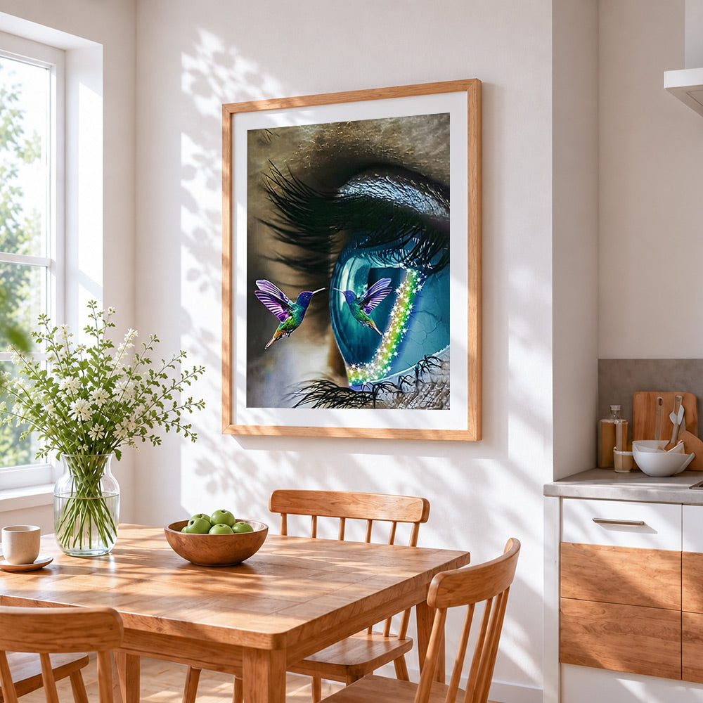 Surreal blue eye and a hummingbird cross stitch artwork displayed on wall as home decor