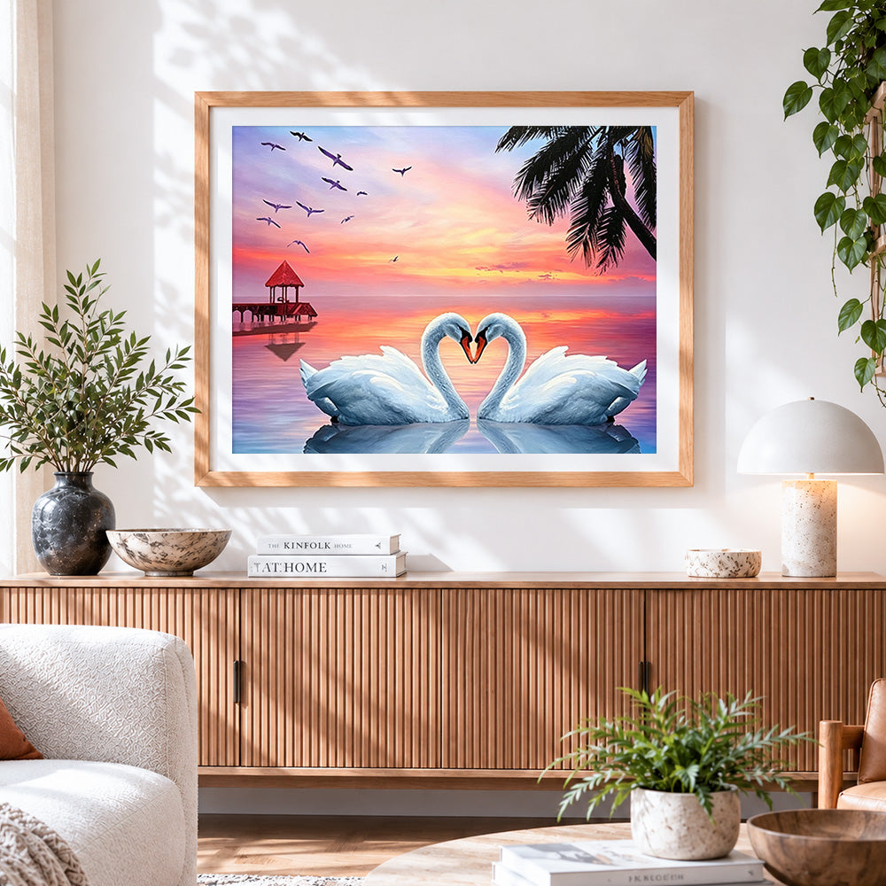 Finished swans forming a heart at sunset cross stitch artwork displayed