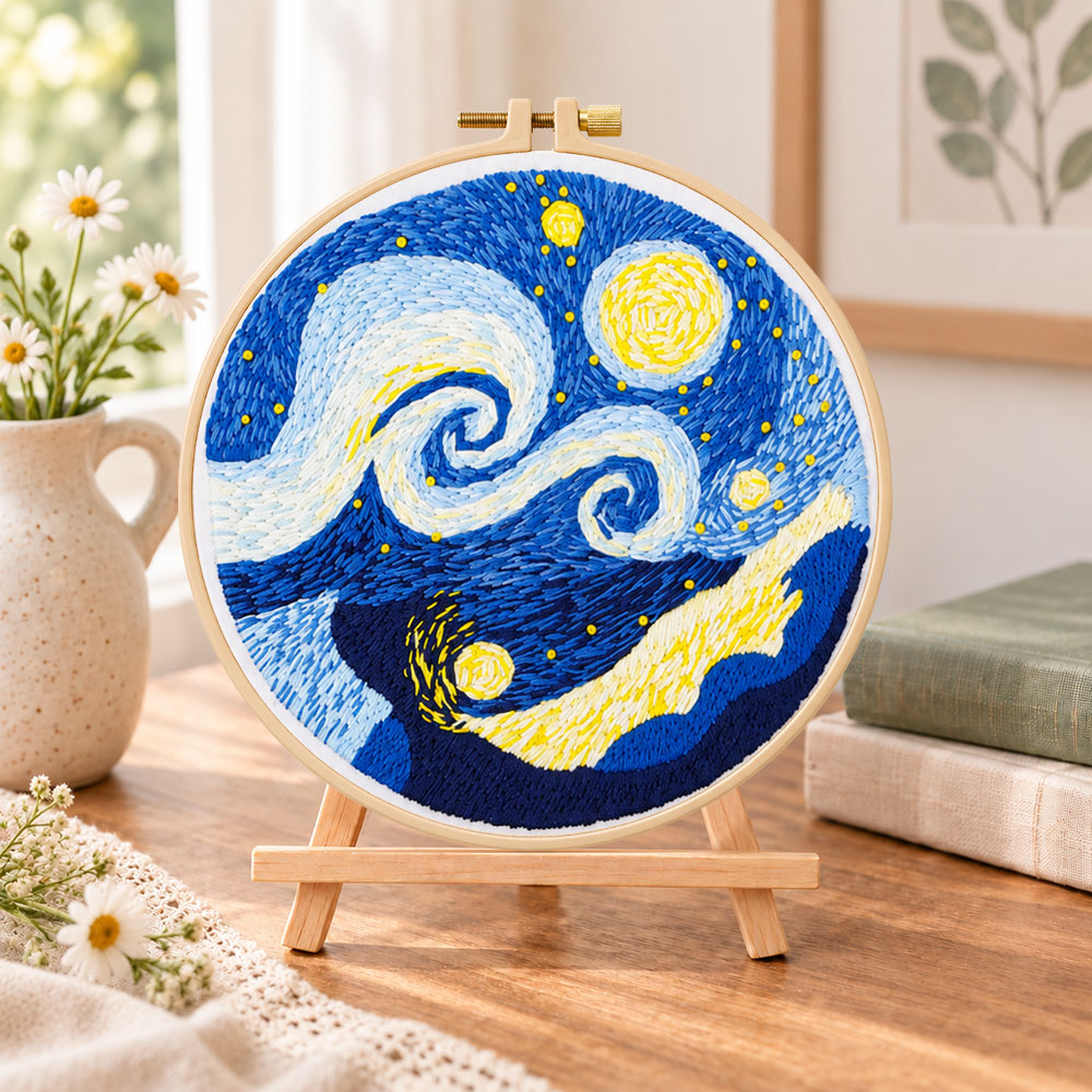 Swirling starry sky art embroidery kit finished hoop displayed on a wooden stand as cosy tabletop decor