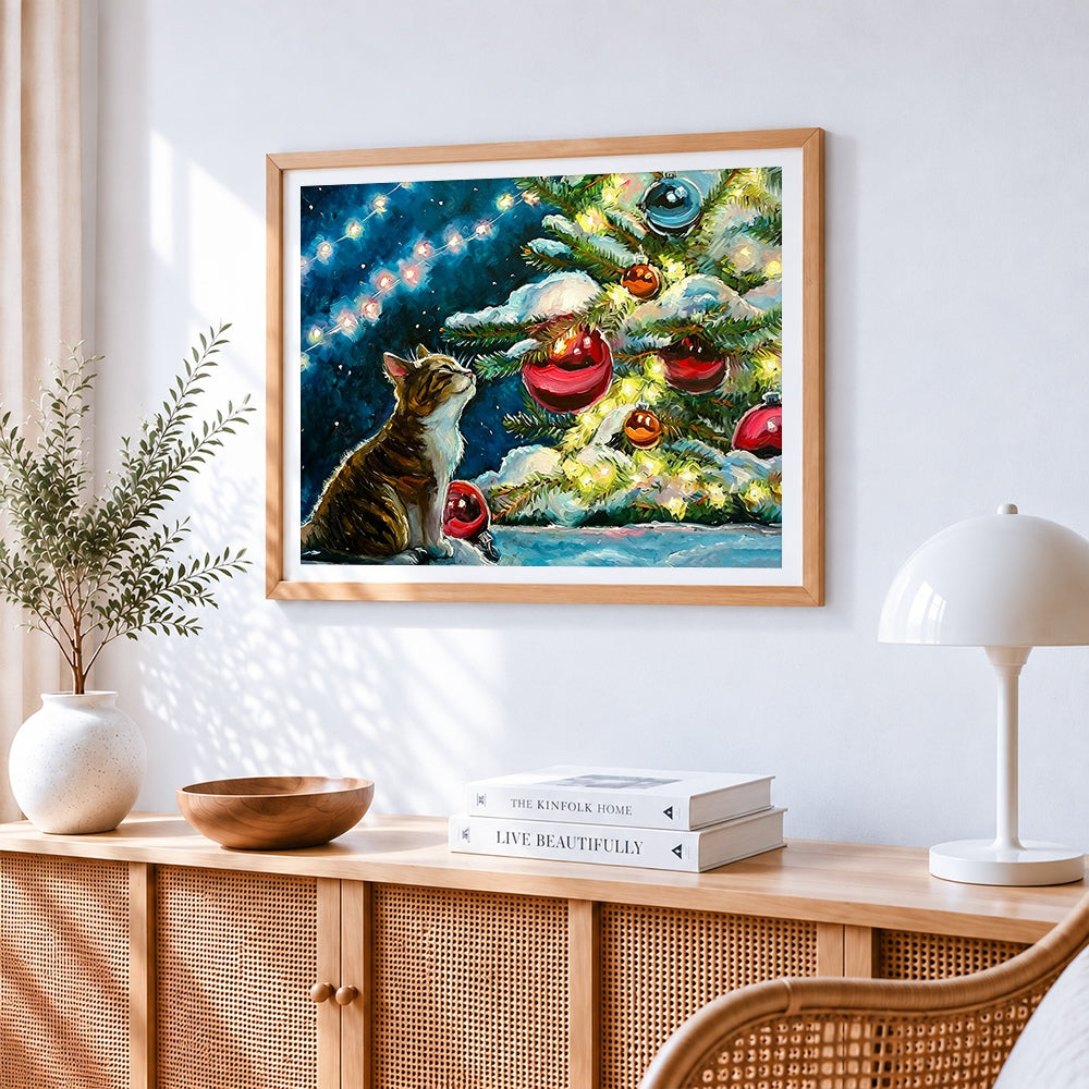 Tabby cat watching the christmas tree cross stitch artwork displayed on wall as home decor