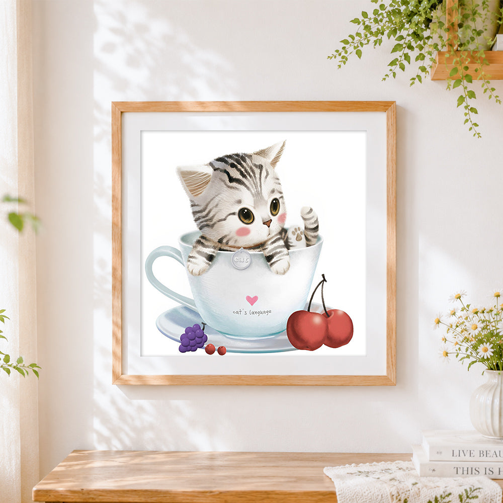 Finished tabby kitten in teacup with fruit cross stitch artwork displayed