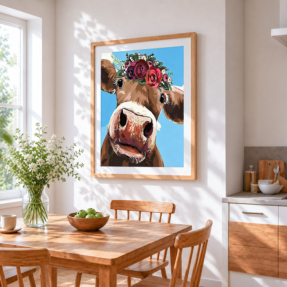 The curious cow with flower crown cross stitch artwork displayed on wall as home decor