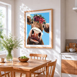 The curious cow with flower crown cross stitch artwork displayed on wall as home decor
