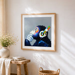 Thoughtful chimpanzee with colourful headphones cross stitch artwork displayed on wall as home decor