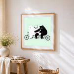 Three bears on a bicycle cross stitch artwork displayed on wall as home decor