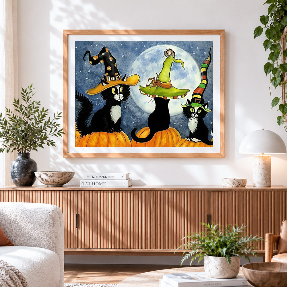 Finished three black cats in witch hats on pumpkins cross stitch artwork displayed