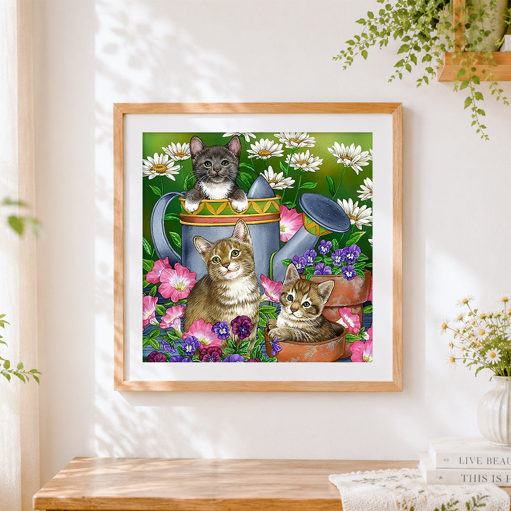 Finished three kittens in garden watering can cross stitch artwork displayed