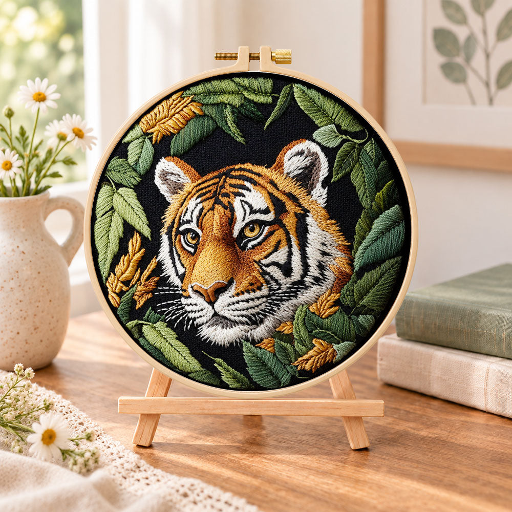 Tiger in dark foliage embroidery kit finished hoop displayed on a wooden stand as cosy tabletop decor