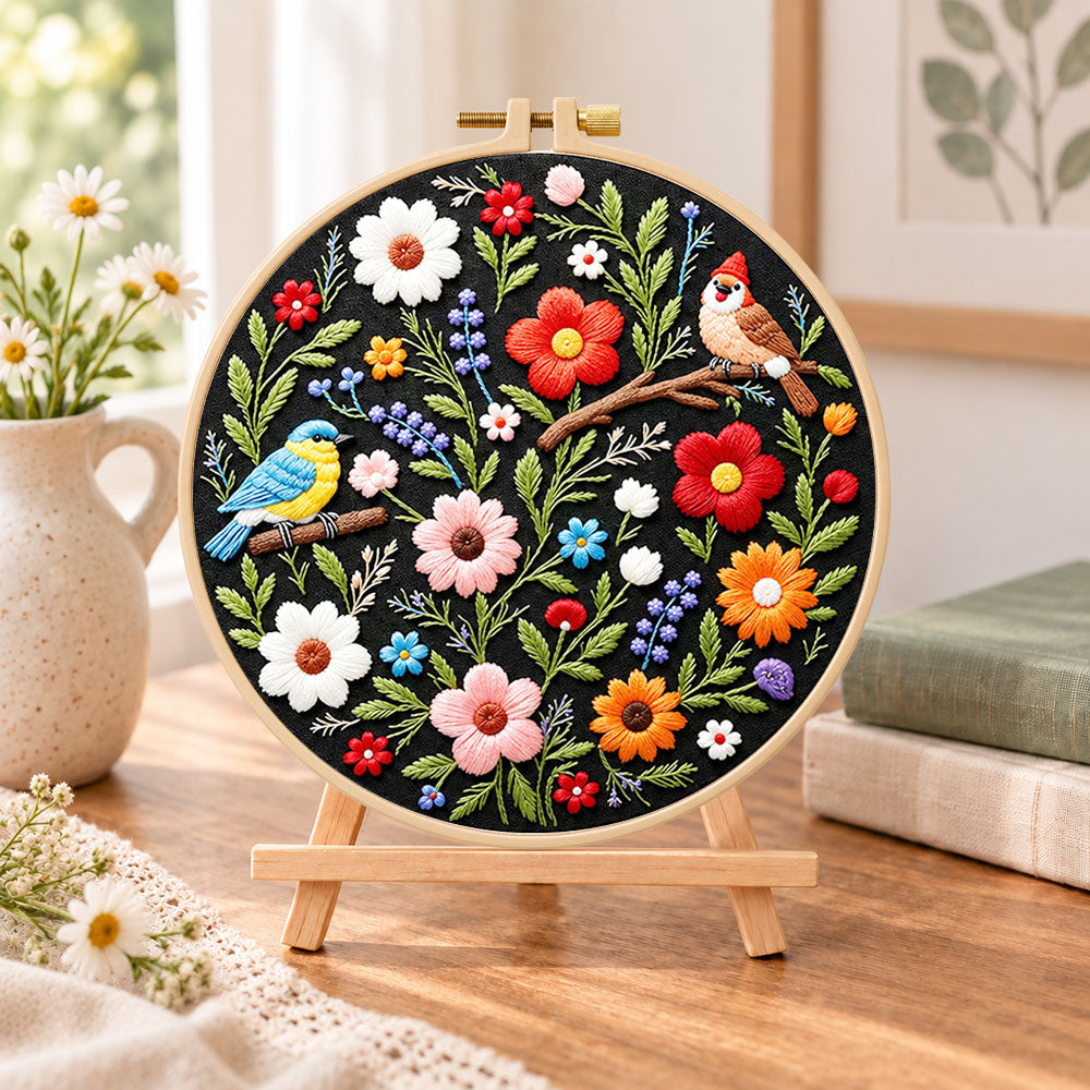 Titmouse and colourful wildflowers embroidery kit finished hoop displayed on a wooden stand as cosy tabletop decor