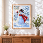 Finished traditional snowman and red cardinal bird cross stitch artwork displayed