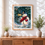 Finished traditional snowman with lantern in a winter forest cross stitch artwork displayed