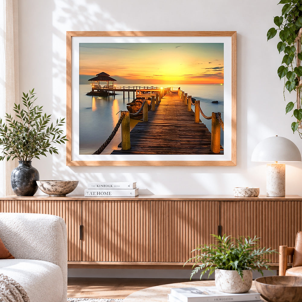 Finished tropical sunset pier and gazebo cross stitch artwork displayed