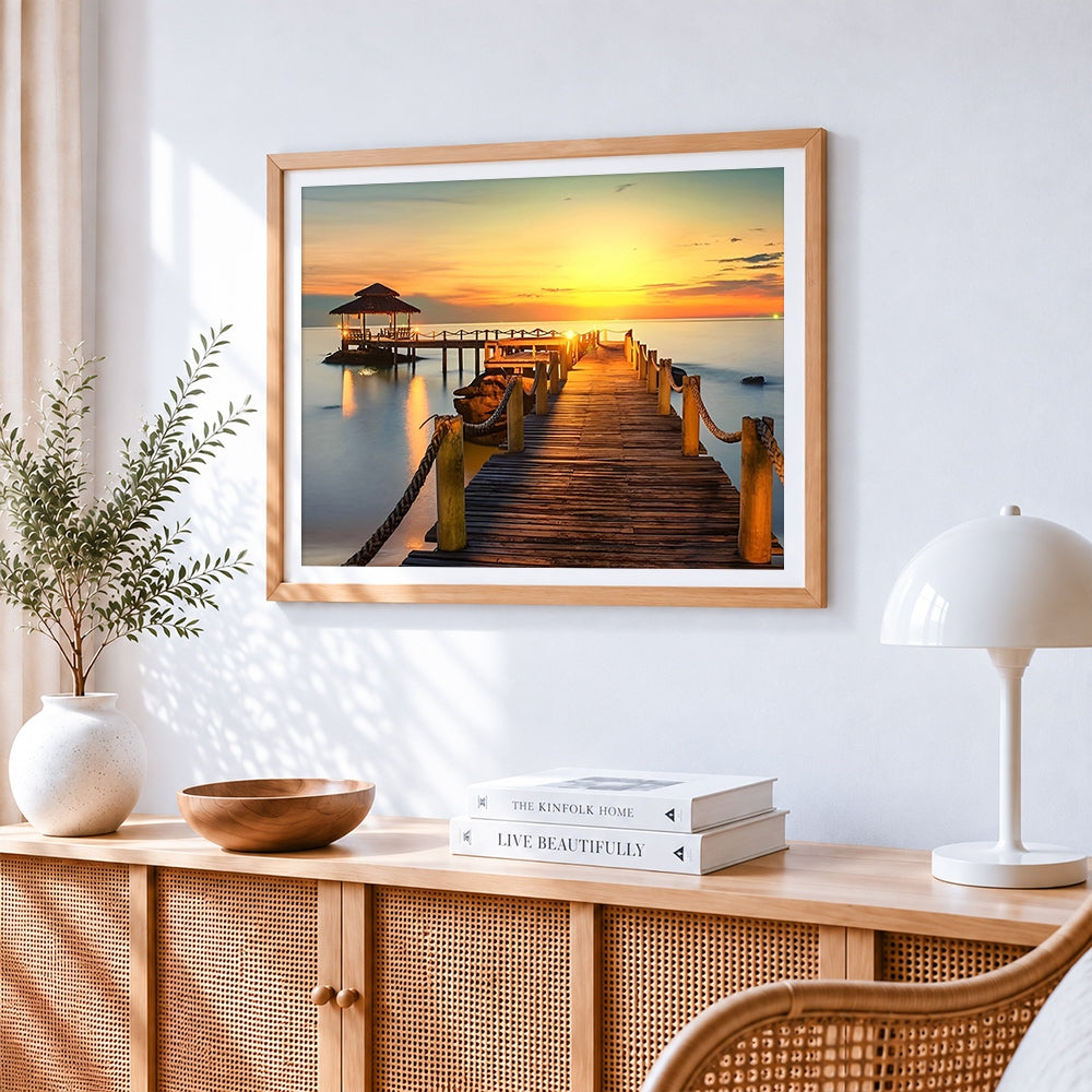 Tropical sunset pier and gazebo cross stitch artwork displayed on wall as home decor