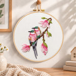 Two birds on magnolia branch embroidery hoop wall art displayed as warm and cosy handmade home decor