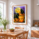 Two black cats on pumpkins under a full moon cross stitch artwork displayed on wall as home decor