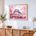 Two bluebirds on a cherry blossom branch cross stitch artwork displayed on wall as home decor