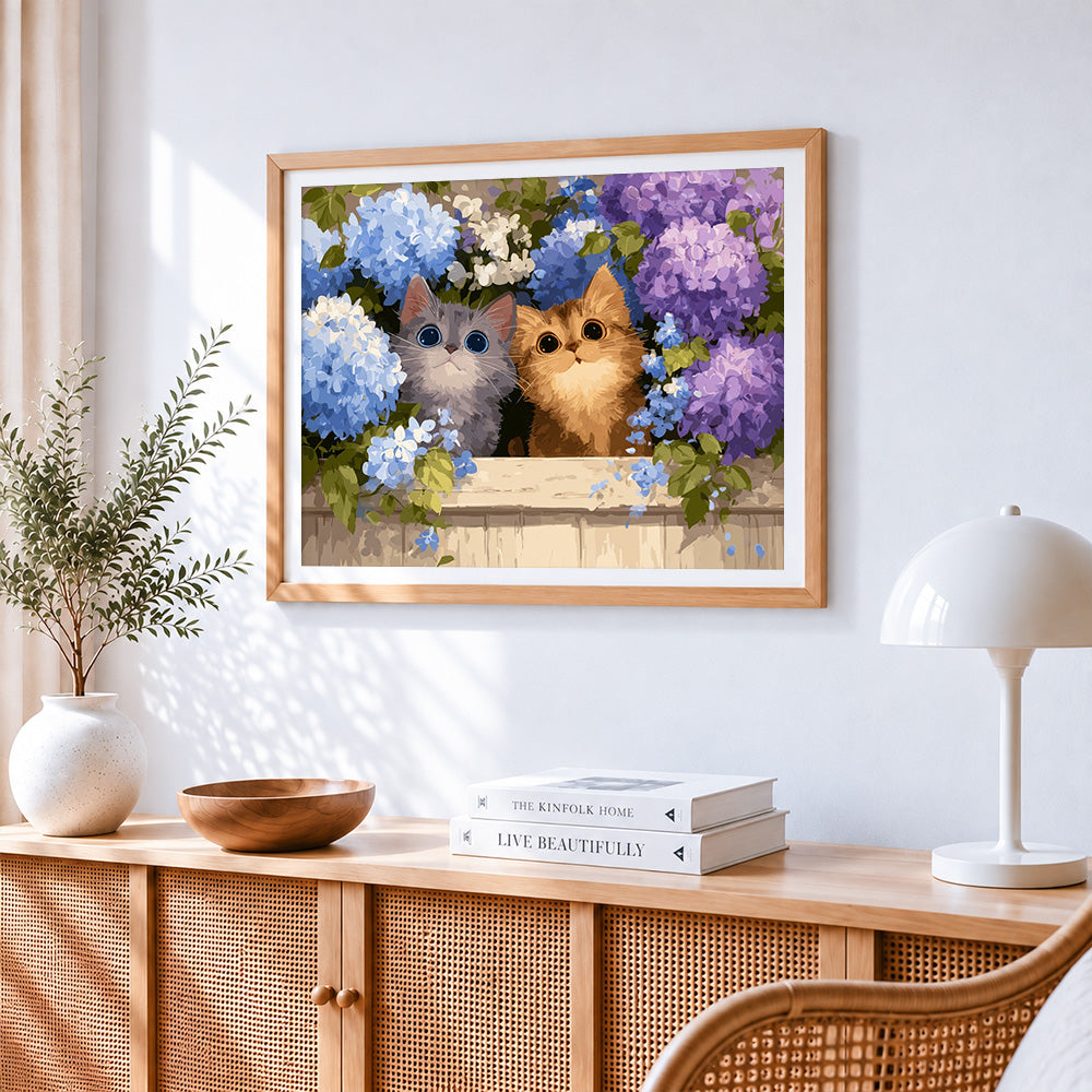 Two cute kittens in blue hydrangeas cross stitch artwork displayed on wall as home decor