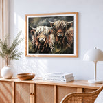 Two highland cows cross stitch artwork displayed on wall as home decor