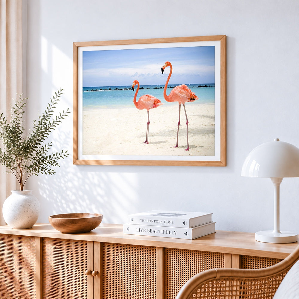 Two pink flamingos on tropical beach cross stitch artwork displayed on wall as home decor