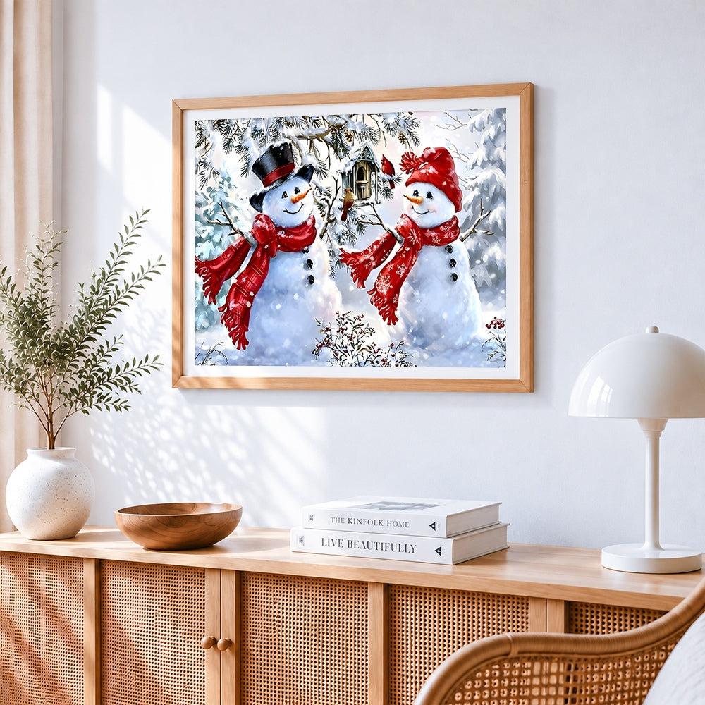 Two snowmen with birdhouse cross stitch artwork displayed on wall as home decor
