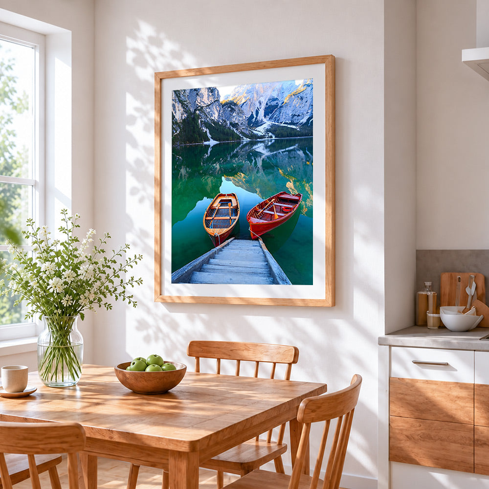 Two wooden boats on a turquoise lake cross stitch artwork displayed on wall as home decor
