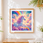 Finished unicorn resting on a rainbow cross stitch artwork displayed